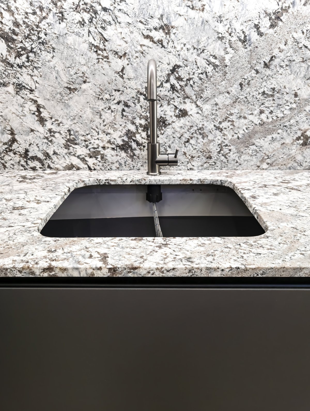 Modern kitchen with dark countertops and finished cabinetry