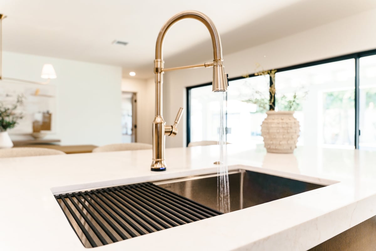 Contemporary kitchen with a large white quartz island and farmhouse sink